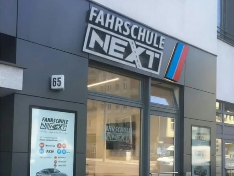 Entrance of Fahrschule Next at Perleberger Straße 65 with illuminated sign